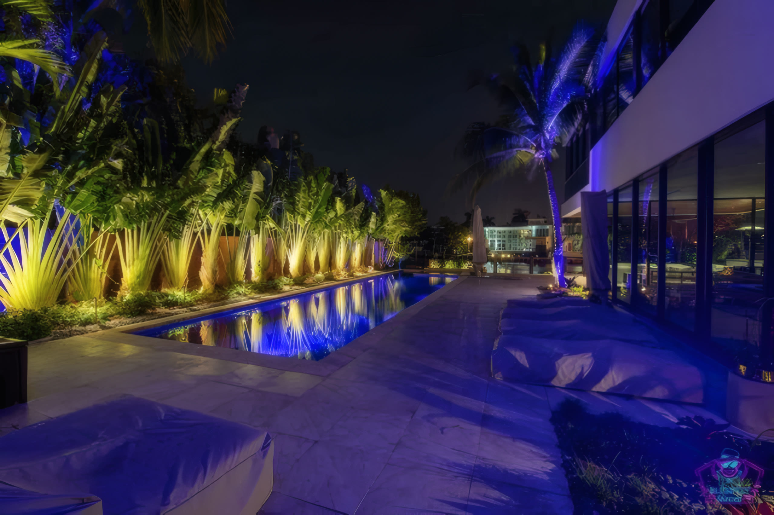Pool house at twilight with palm reflections in the water